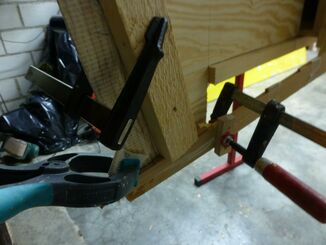 Pressing down and fixing the end of the strips at the bow and stern malls with wood pegs and clamps